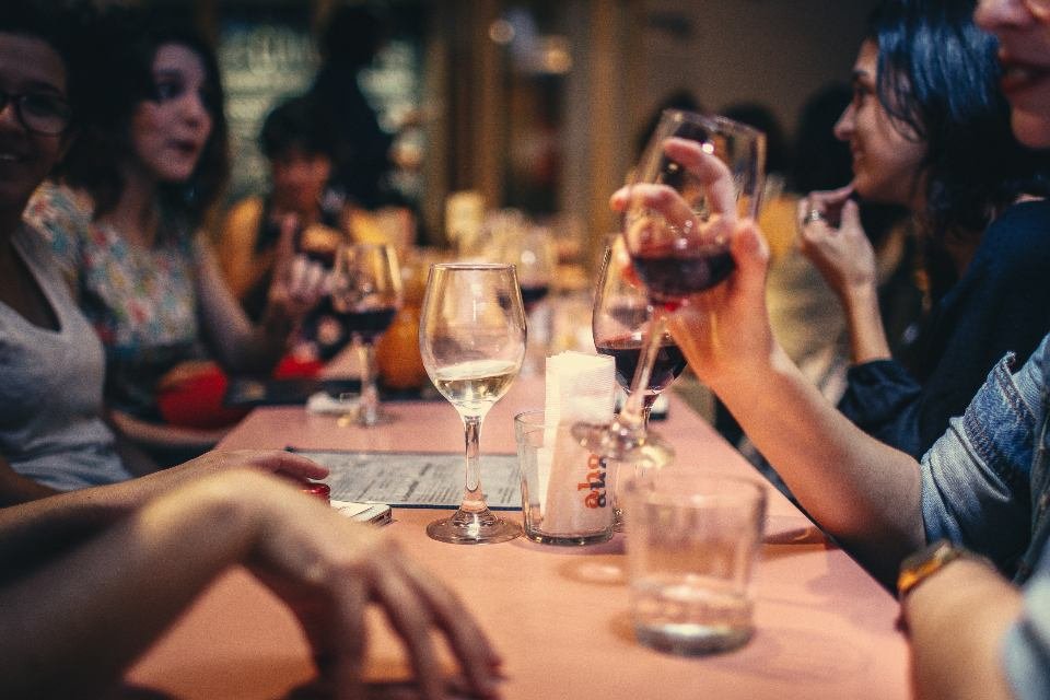 Convives attablés autour de verres de vin dans la salle du bistrot